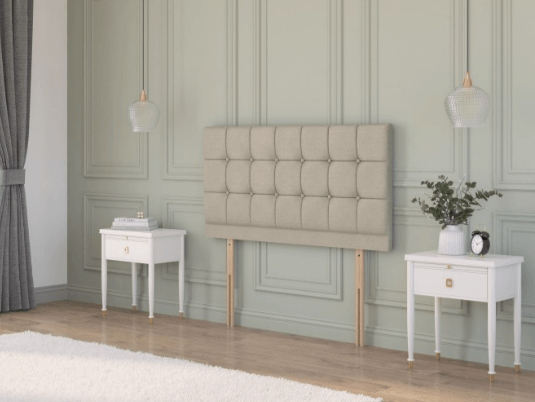 Chesterfield floor standing headboard in beige velvet, displayed between two black bedside tables in a classic interior.